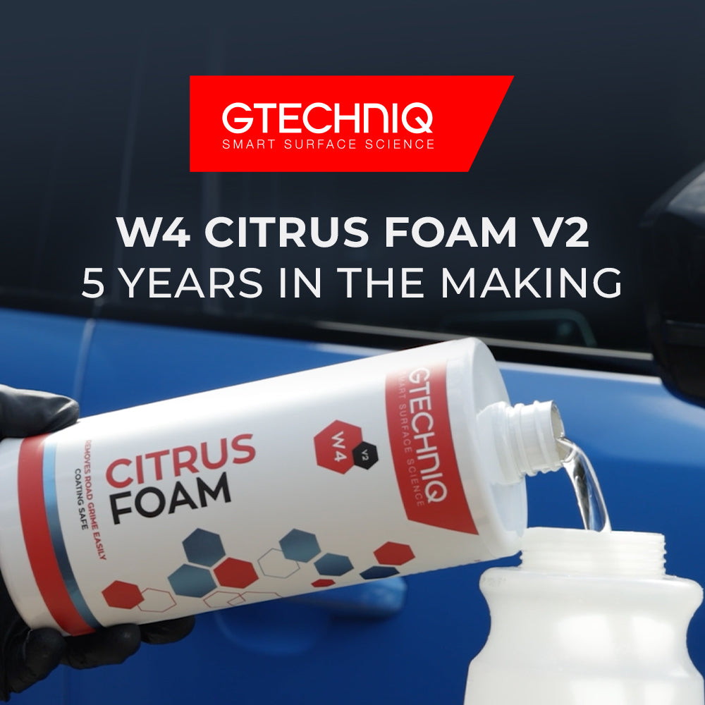 Gtechniq W4 Citrus Foam V2 being poured into a snow foam lance bottle in front of a blue car